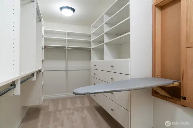 Generously-sized walk-in closet in primary suite with built-ins, and convenient ironing board