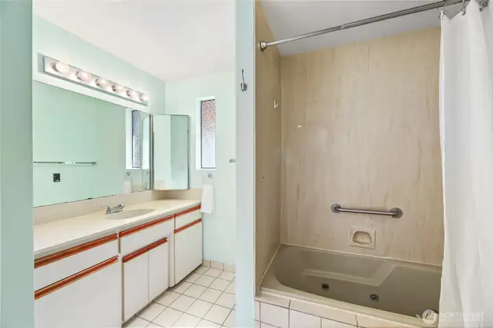 HALL FULL BATH  Jetted tub   Single sink vanity with 2 corner mirrored medicine cabinets with cream flat face cabinets with wood trim  Heated vent  Pocket door entry / Frosted window / Tile floor
