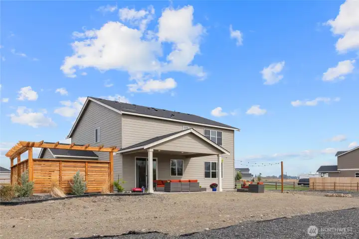 Backyard, with additional patio space, thoughtfully designed privacy arbor, and covered patio.