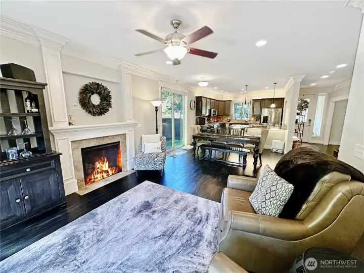 From great room looking to kitchen and dining area. Charming gas fireplace keeps things cozy.