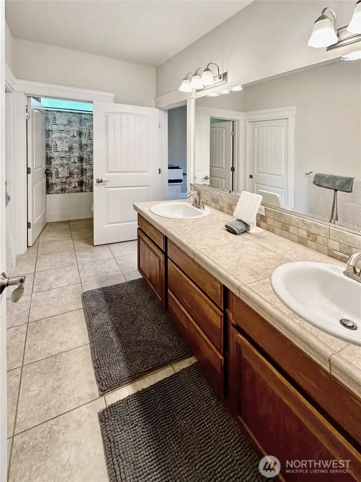 Upper hall bath offers double vanities.
