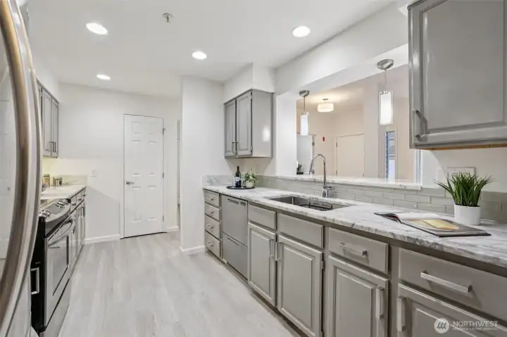 Kitchen has ample lighting, cabinetry & pantry.