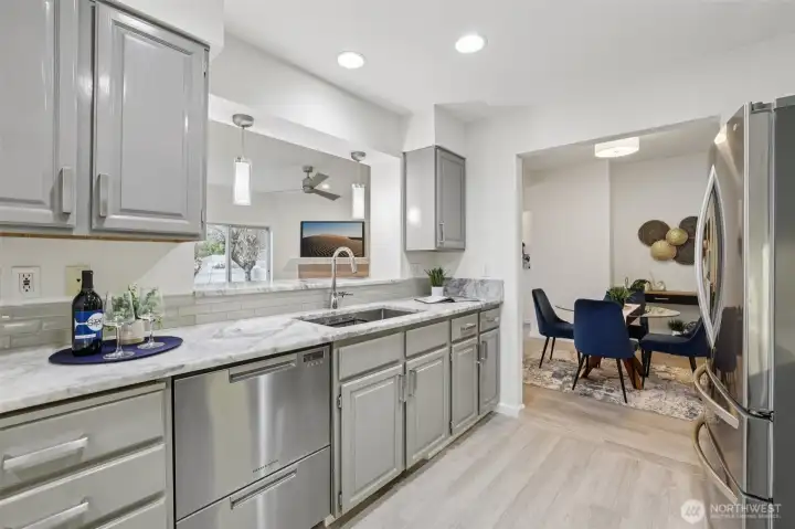 Painted cabinetry, quartz countertops, SS appliances, new flooring in kitchen.