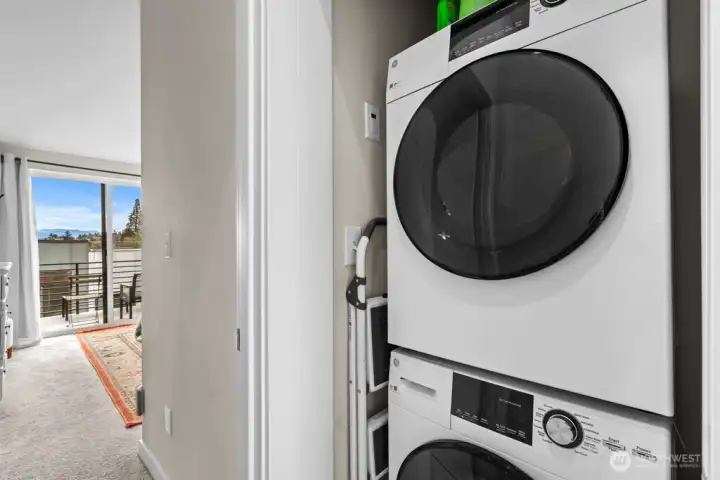 Stackable washer/dryer stays with the townhome, located in the hallway next to the primary bedroom on level 3