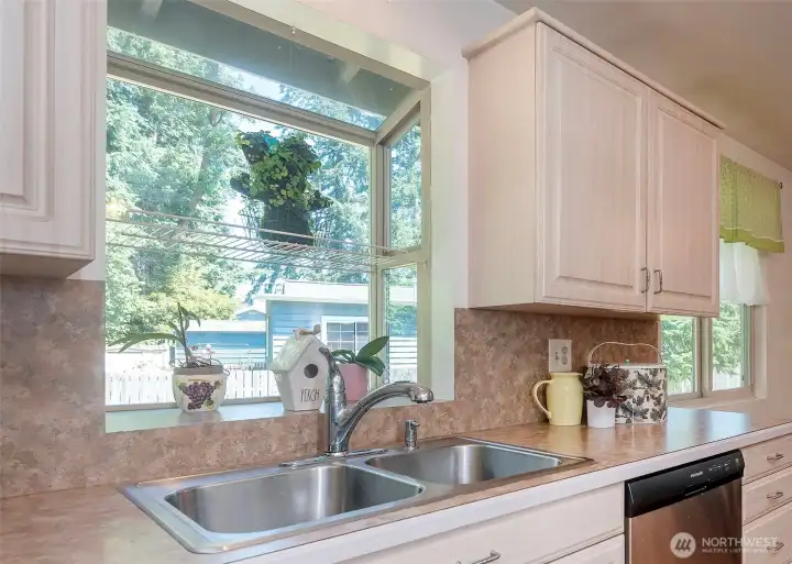 The quintessential kitchen window overlooks the beautifully maintained backyard, providing a picturesque view and bringing natural light into the heart of the home.
