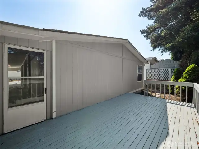 Out the back of the carport, you will find this HUGE, PRIVATE deck! Trees all around, very quiet and peaceful.