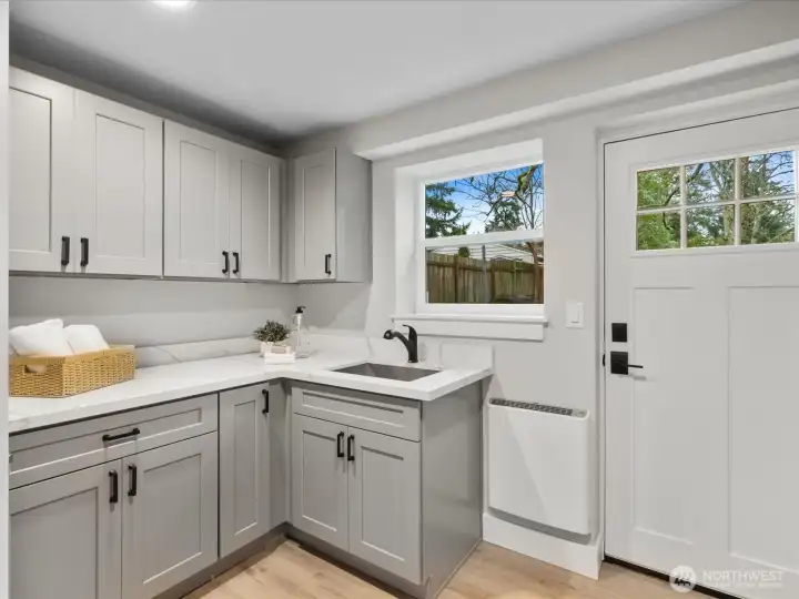 Large laundry room with cabinets, sink, and heat