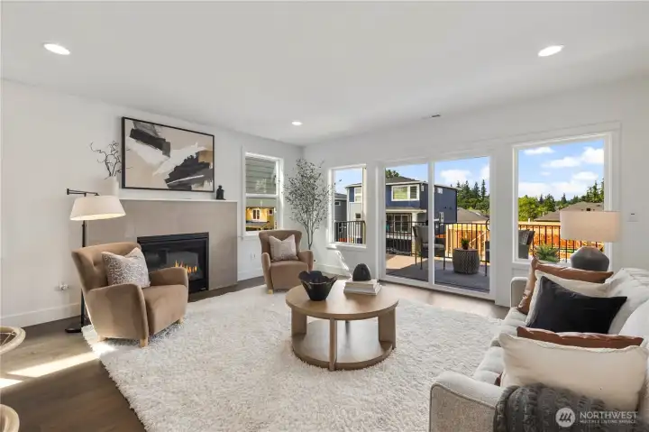 Great Room with Fireplace: Anchored by a sleek tile-surround gas fireplace, the great room offers comfort and style in equal measure. Oversized windows frame neighborhood views, while the open design makes this a natural hub for daily living.  These photos are of the actual, staged home being sold at Foxmoore. However, all photos, renderings, site maps, and floorplans are for visualization purposes only. Plans, colors, building orientation, finishes, home outlook, and other details can and WILL vary.