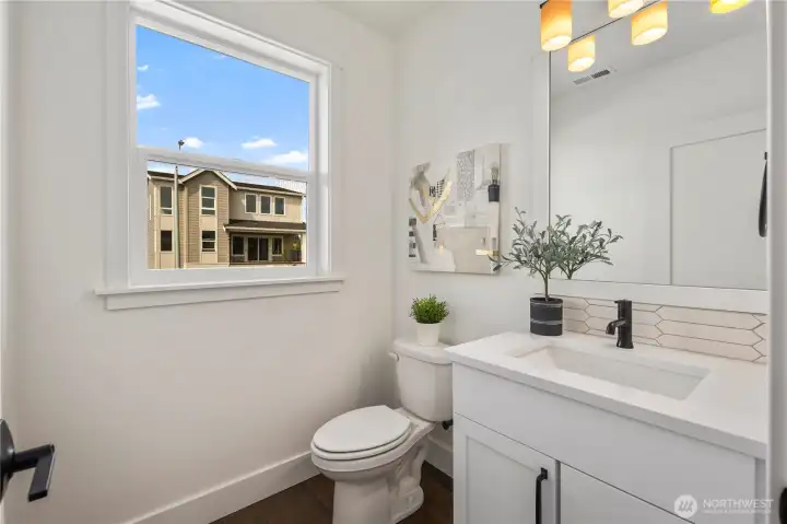 Powder Bath: Main-level powder bath features contemporary finishes, including a quartz-topped vanity and designer lighting. A bright window completes this polished space for guests and daily convenience.  These photos are of the actual, staged home being sold at Foxmoore. However, all photos, renderings, site maps, and floorplans are for visualization purposes only. Plans, colors, building orientation, finishes, home outlook, and other details can and WILL vary.