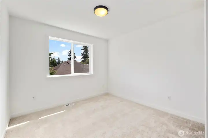 Upper Bedroom: Light-filled secondary bedroom with soft carpet and a large window overlooking the neighborhood. Neutral finishes make it easy to personalize for any use.  These photos are of the actual, staged home being sold at Foxmoore. However, all photos, renderings, site maps, and floorplans are for visualization purposes only. Plans, colors, building orientation, finishes, home outlook, and other details can and WILL vary.