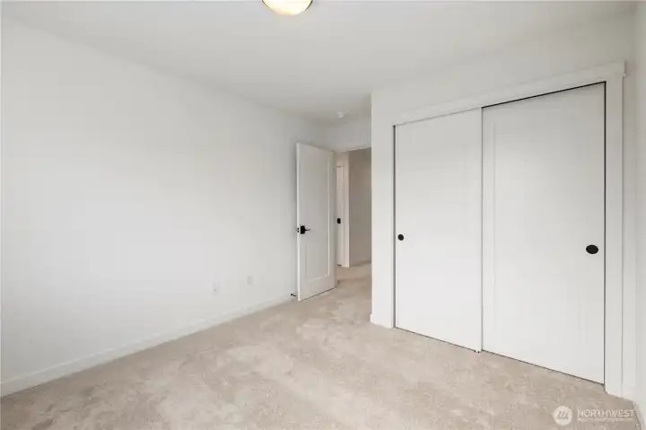 Upper Bedroom (alternate angle): Another view of the secondary bedroom highlights the generous closet space and connection to the upstairs hall. A versatile room ready to meet your needs.  These photos are of the actual, staged home being sold at Foxmoore. However, all photos, renderings, site maps, and floorplans are for visualization purposes only. Plans, colors, building orientation, finishes, home outlook, and other details can and WILL vary.