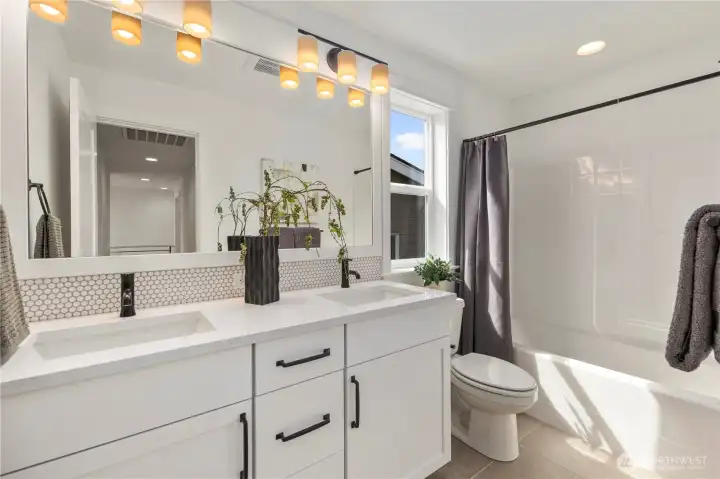 Upper Hall Bathroom: Full bathroom with double-sink vanity, modern fixtures, and a tub/shower combo. Thoughtfully designed to serve the secondary bedrooms upstairs.  These photos are of the actual, staged home being sold at Foxmoore. However, all photos, renderings, site maps, and floorplans are for visualization purposes only. Plans, colors, building orientation, finishes, home outlook, and other details can and WILL vary.
