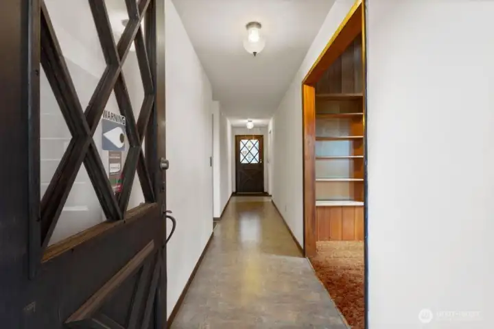 Main entry with access to a large deck and view of the front of the property.