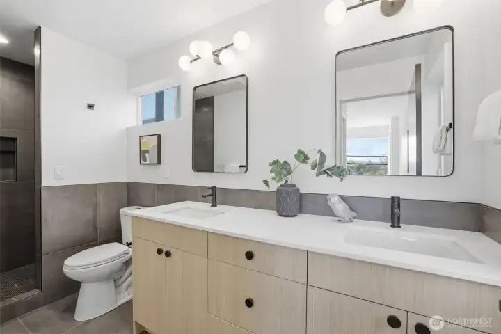Spa-inspired primary bathroom with double vanity, quartz countertops, designer tile shower, and luxury new construction finishes.
