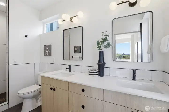 Spa-inspired primary bathroom with double vanity, quartz countertops, designer tile shower, and luxury new construction finishes.