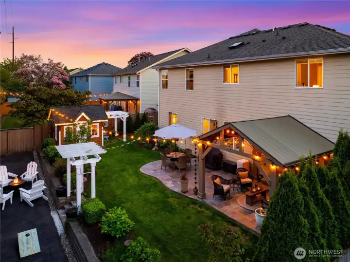 The yard is an oasis. Covered seating and a fire pit.