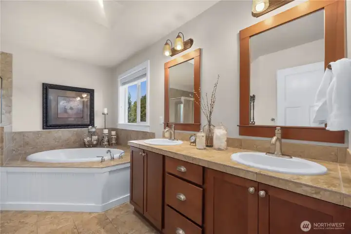 Ensuite bathroom off the primary has dual sinks, tub and separate shower.