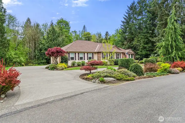 Circular concrete driveway even has decorative edge treatment - offers convenient guest parking while driveway at left leads to oversized 3-car garage.