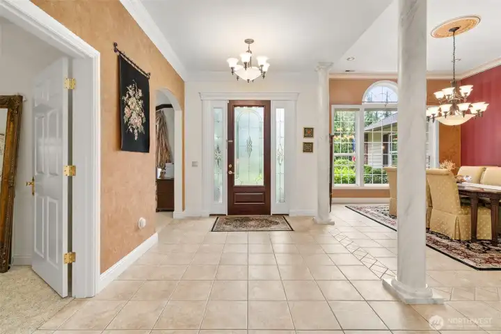 A look back toward the 8ft front door. 10 - 12 ft ceilings throughout this custom home ensure a spacious, airy feel. Dining room at right, arched doorway to left of entry leads to office.