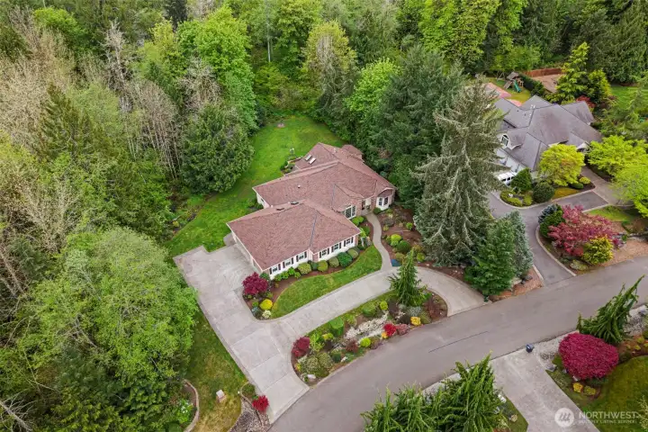 Just look at that colorful mature landscape - plants chosen for year-round color. Circular concrete driveway and more off-street parking near the garage.