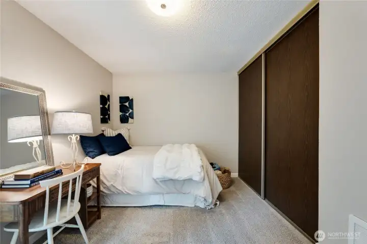 Floor-to-ceiling closet has sliding doors and also new shelving/rod inside.