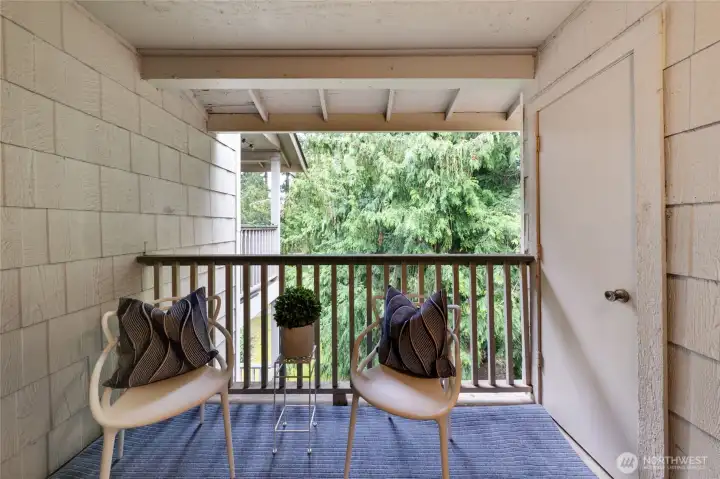 Covered balcony has enough space for seating and faces east with a tree-lined view. Balcony closet is great for extra storage.