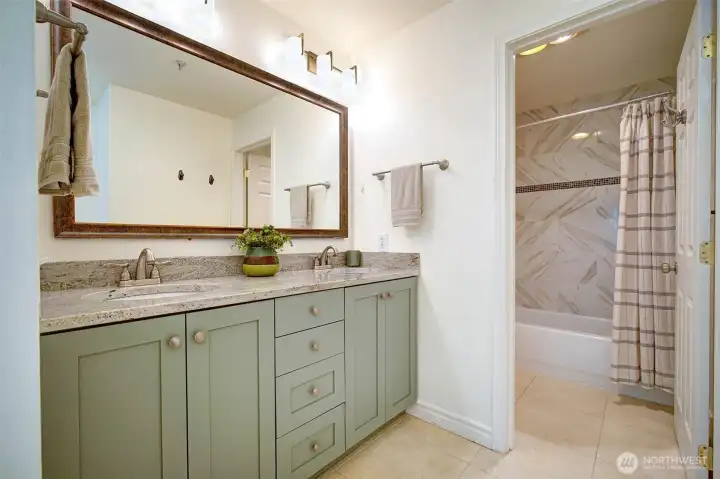 Updated primary bathroom with dual sinks & separate tub/shower/commode room.