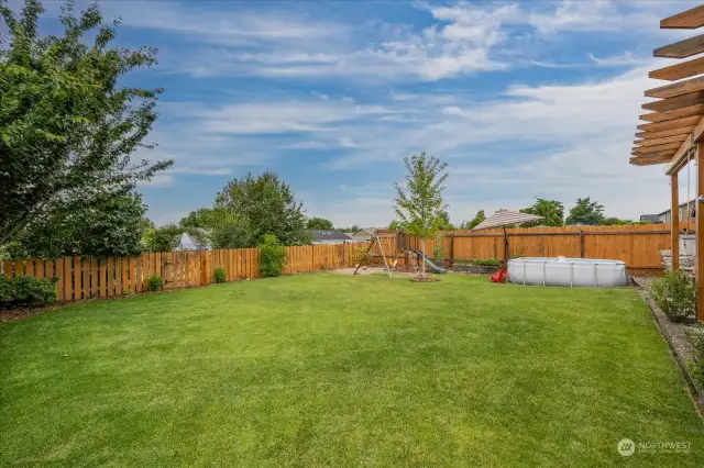 Fully fenced yard with mature trees and landscaping