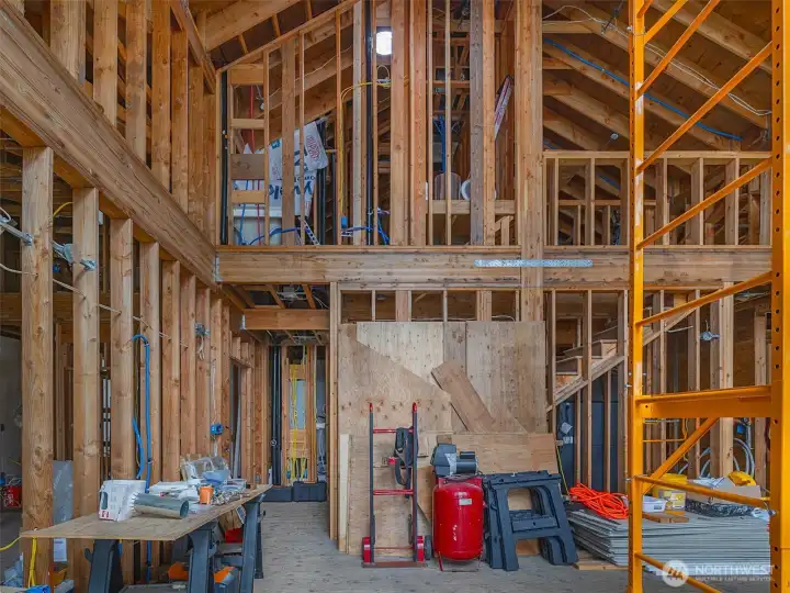 photo showing the great room with master bedroom and full master bath at left. Upstairs is a bonus room with a separate loft space. Computer room at center of upper loft area.