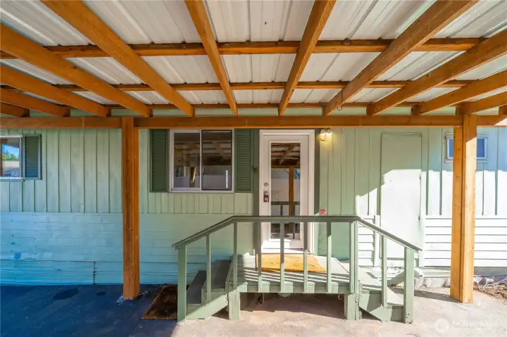 Covered side entry under the carport offers easy, weather-protected access to the home year-round.