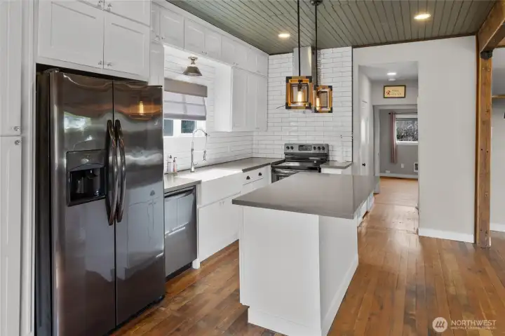 Stunning kitchen shows view of hall towards main floor bedroom and bathroom.
