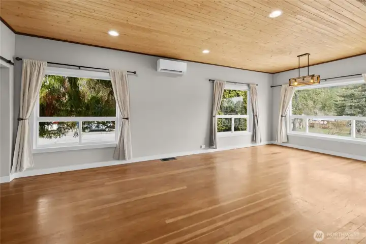 View of the massive dinging and living room area. Take in the update lighted windows and lighting, combined with the original wood gives the home so much character.