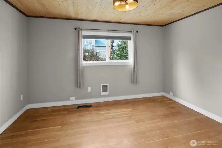 Large main floor bedroom with original wood floors and ceiling. This bedroom is next to the main floor restroom, only a few steps away.