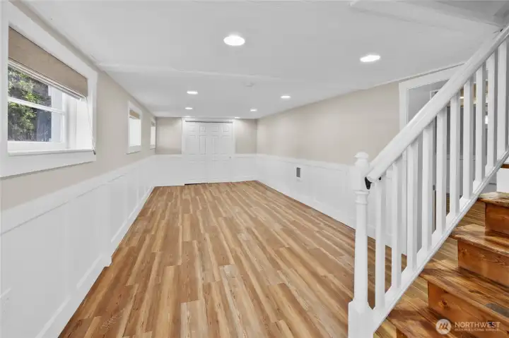 Once you arrive at the bottom of the stairs is one of the 2 lower floor bedrooms. Perfect for a couple of sets  bunk beds to accommodate more sleeping space. The charming wainscot gives this area such a classy vibe. This area was one the lower level garage if you want to convert back to storage space.