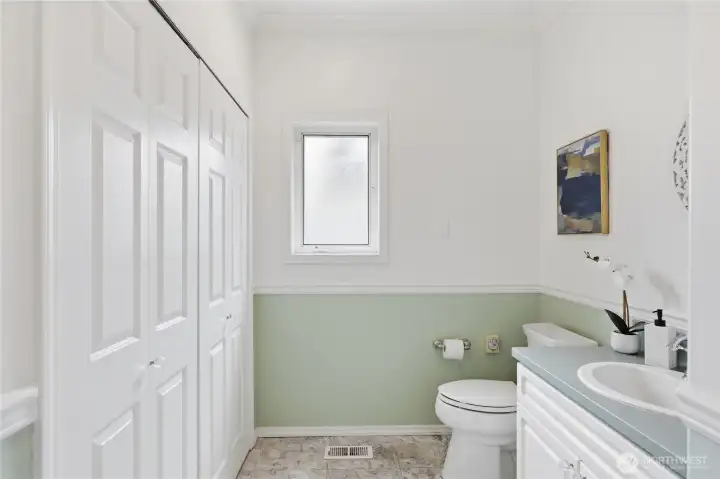 Hall bath/powder room has laundry closet with laundry sink on left