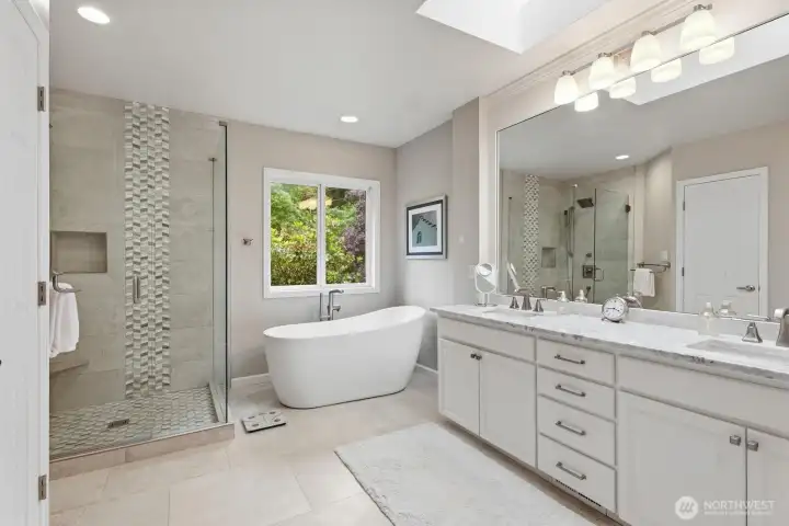 With a beautifully remodeled spa-inspired bath featuring a designer-tiled shower with rain shower head and seamless shower glass, freestanding soaking tub, slab granite vanity, and the custom walk-in closet includes thoughtfully designed built-in organization.