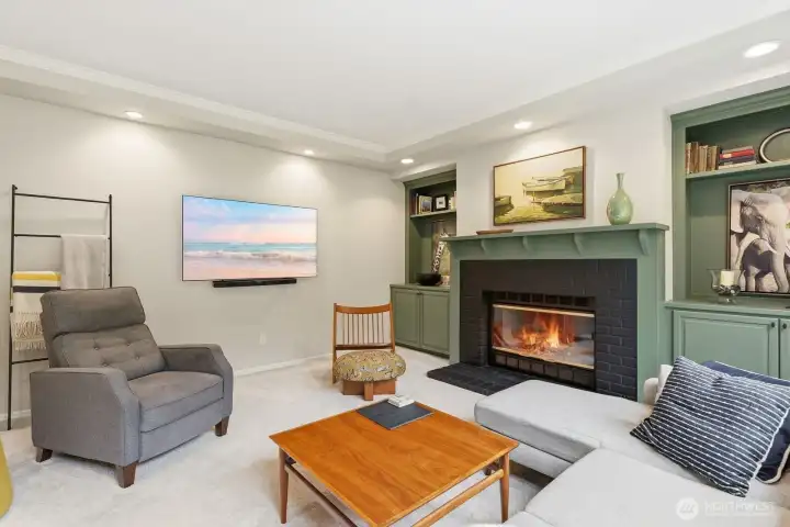 The warm and comfortable family room features a cozy gas fireplace, custom built-ins, and seamless connection to the heart of the home.