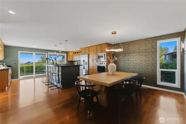 The kitchen flows into the spacious and elegant dining room, complete with custom wallpaper and beautiful light fixtures. The kitchen flows into the spacious and elegant dining room, complete with custom wallpaper and beautiful light fixtures.