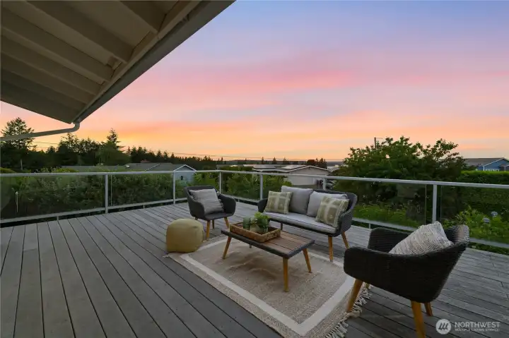 Through the kitchen sliders, step outside to the expansive Trex deck, perfect for evening gatherings and ever-changing sunsets. Through the kitchen sliders, step outside to the expansive Trex deck, perfect for evening gatherings and ever-changing sunsets.