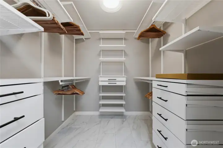 The practical walk-in closet features custom organizers and durable tile flooring. The practical walk-in closet features custom organizers and durable tile flooring.
