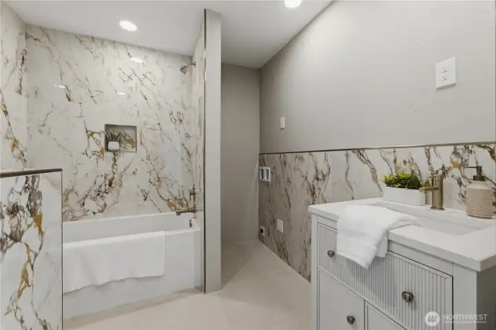 The updated full hall bath conveniently services both downstairs bedrooms. Additional stackable washer and dryer hook-ups offer flexibility for multi-generational living or extended guest stays. The updated full hall bath conveniently services both downstairs bedrooms. Additional stackable washer and dryer hook-ups offer flexibility for multi-generational living or extended guest stays.
