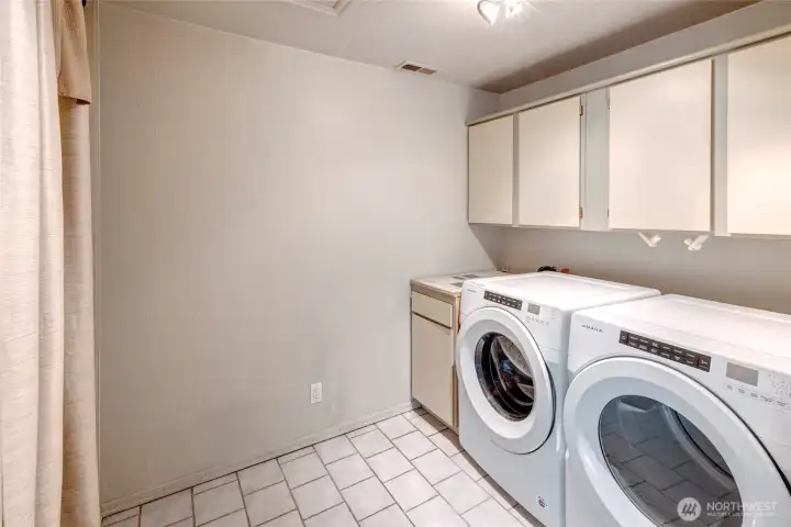 Utility room with washer dryer and hot water closet. Utility room with washer dryer and hot water closet.