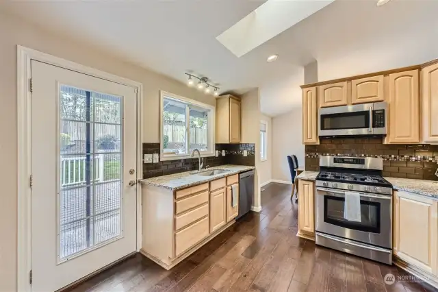 KITCHEN IS ATTRACTIVE AND FUNCTIONAL, DOUBLE DOORS LEAD TO LUXURY DECK.