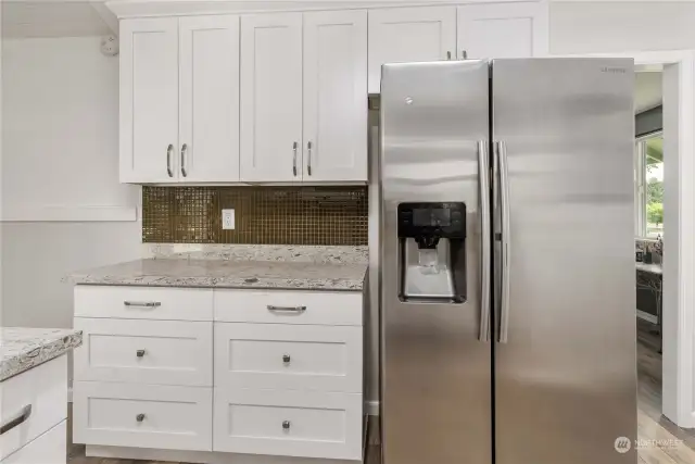 Beautiful cabinets and counters with stainless appliances.