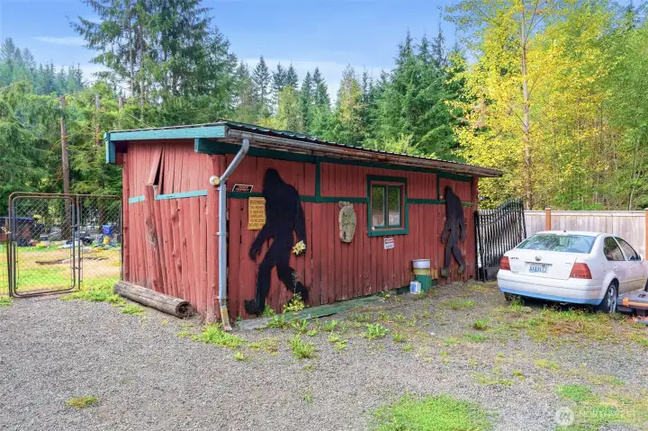 Rustic outbuilding with playful Bigfoot silhouettes painted on the exterior, adding to the property’s legendary charm. This structure offers extra storage or workspace while tying into the home’s unique Bigfoot theme.