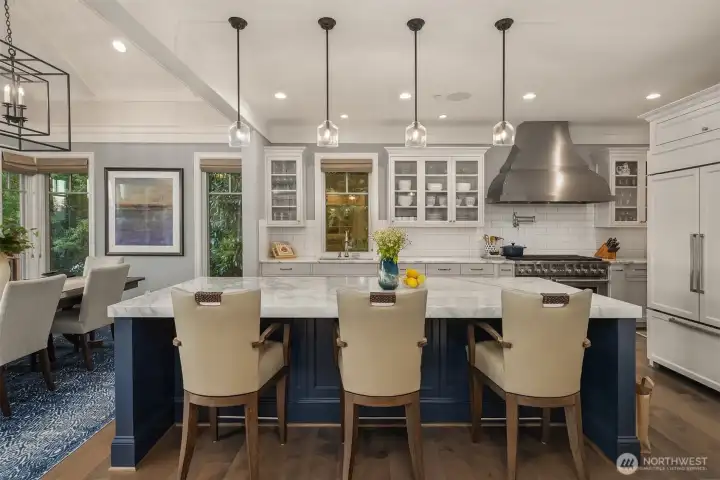 The chef's kitchen is as stunning as it is functional-gleaming with white marble countertops that crown an oversized island.