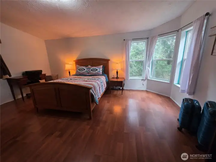 view of trees through primary bedroom windows