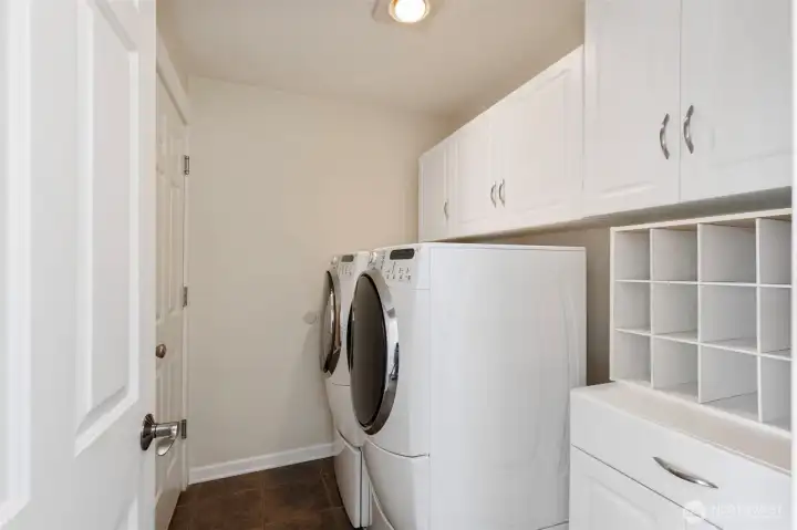 Utility room with even more storage space leads to the garage