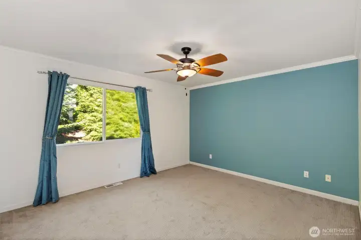 Ceiling fan in large primary bedroom provides year-round comfort