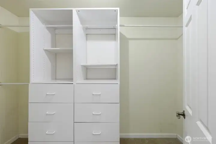 Large walk-in closet attached to primary bedroom with built-ins for storage